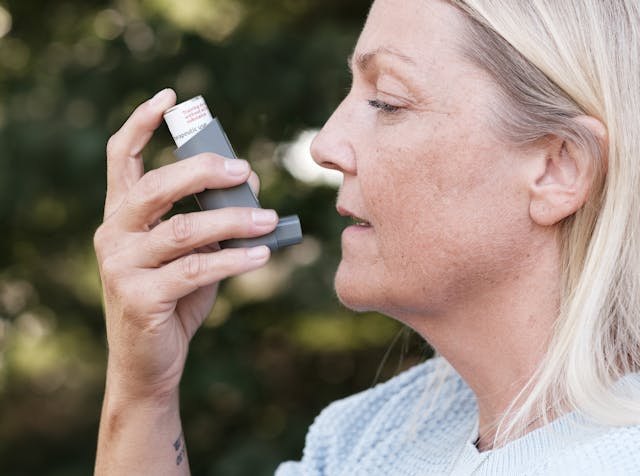 vrouw met inhaler bij long problemen